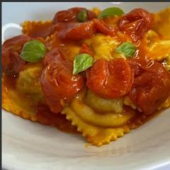 homade ricotta filled ravioli in fresh tomates sauce with parmigiano